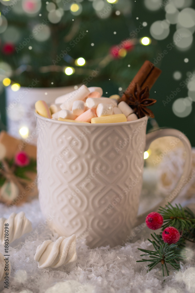 White cup of hot spicy Christmas drink and New Year  decorations. On green background.