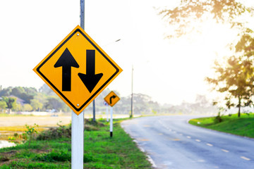 two-way traffic Signs on road with soft-focus and over light in the background