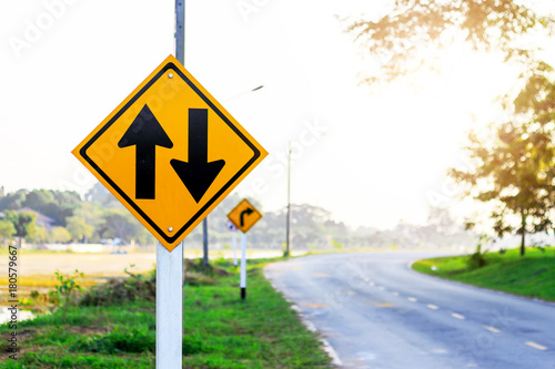 two-way traffic Signs on road with soft-focus and over light in the background