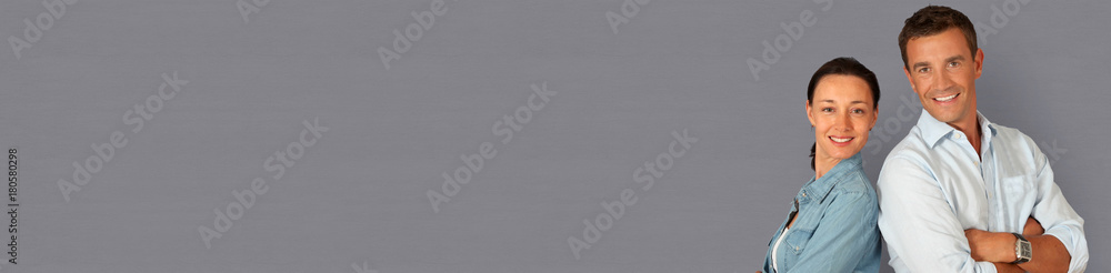 Couple standing on grey background with arms crossed- banner template web Couple standing on grey background with arms crossed- banner template web