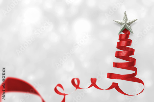 Christmas tree made of red satin ribbon scroll with silver star isolated on white snow background with clipping path for winter xmas holiday greeting card design arts element