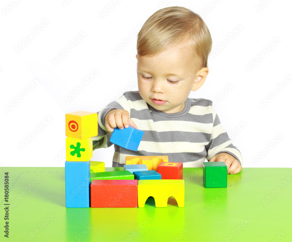 Ein einjähriger Junge spielt mit Holzspielzeug Ein einjähriger Junge spielt mit Holzspielzeug