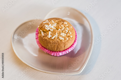 White homemade muffin with sugar on a cute plate, white background