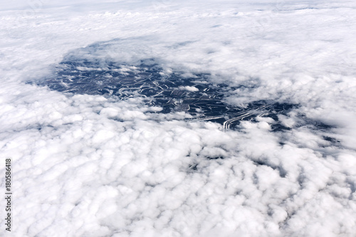 A view from the airplane window to clouds and earth. © Mariiam
