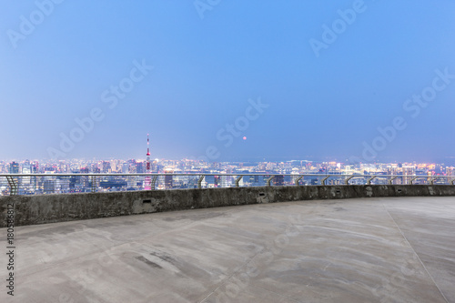 empty concrete floor with modern cityscape at twilight