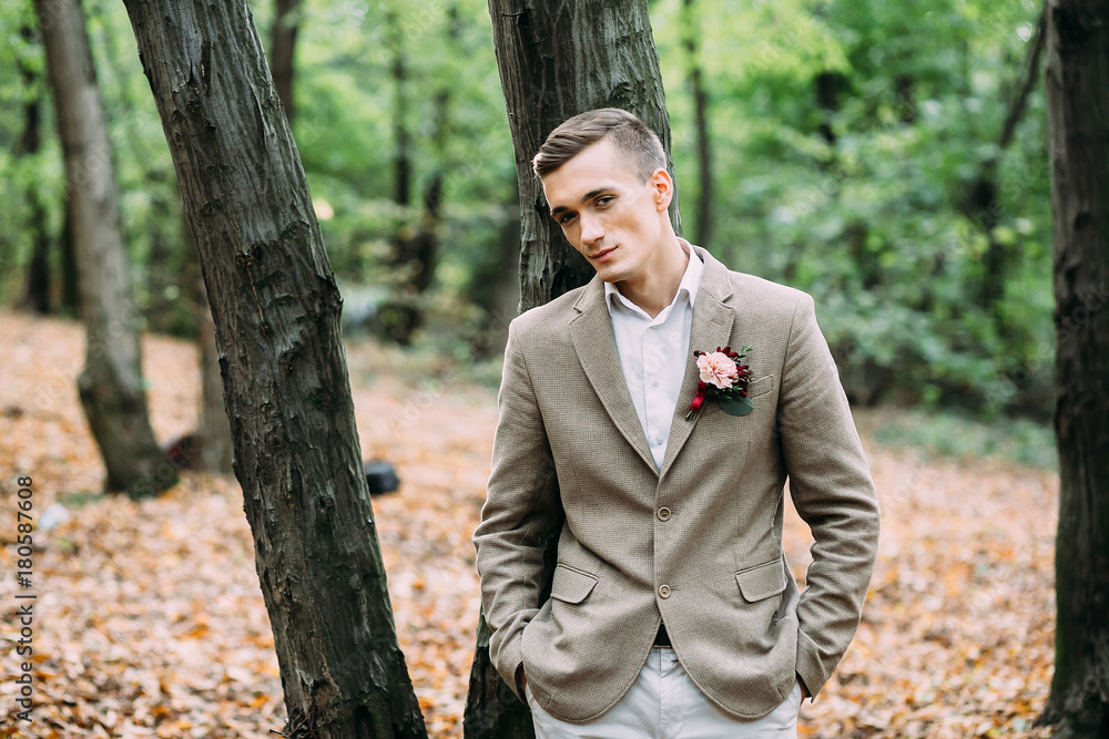 Young handsome man, standing near the tree. Autumn wedding. Soft focus Young handsome man, standing near the tree. Autumn wedding. Soft focus