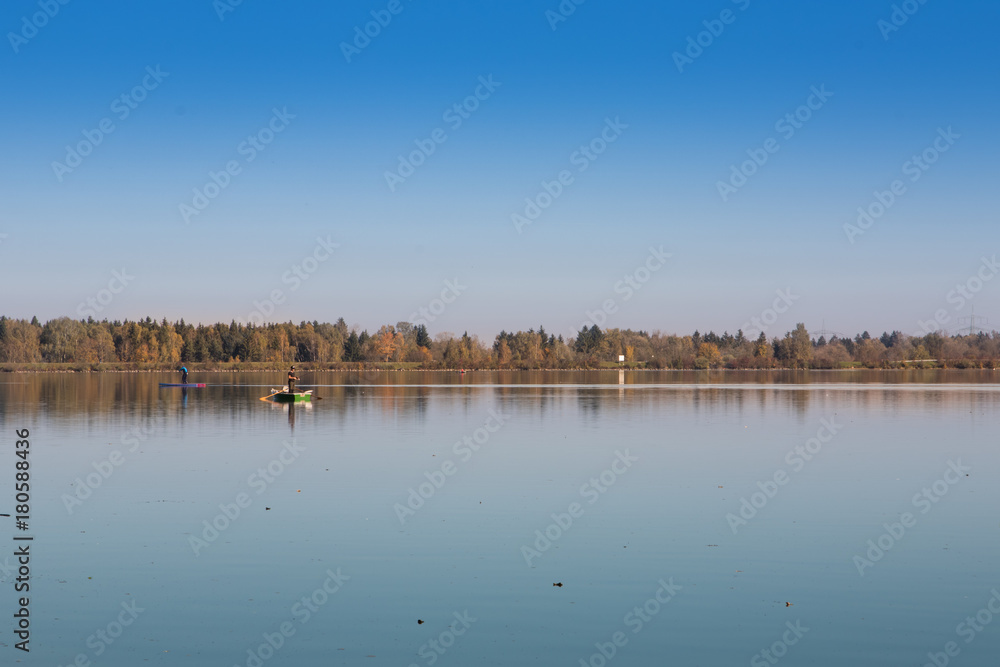 Fototapeta premium Angler und Stehpaddler auf See im Herbst