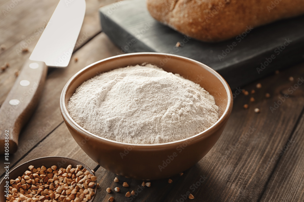Bowl with buckwheat flour on wooden table Bowl with buckwheat flour on wooden table