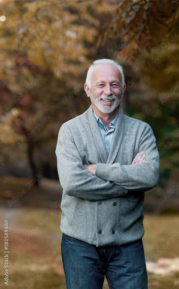 Elderly man smiling outdoors in nature Elderly man smiling outdoors in nature