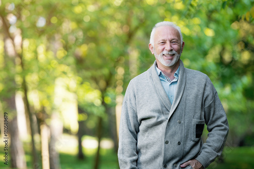 Elderly man smiling outdoors in nature 