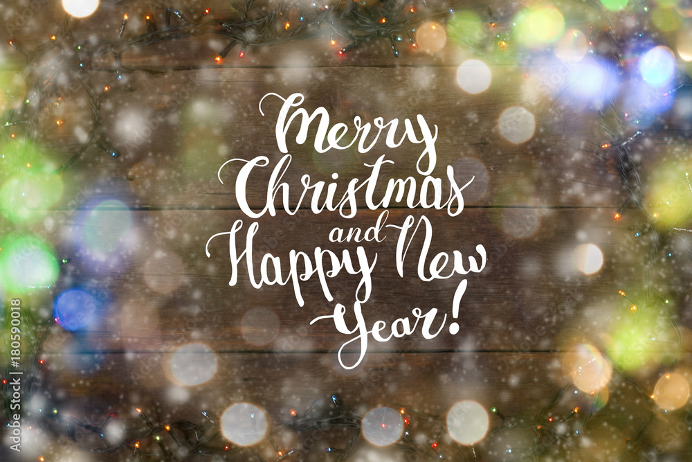 Garlands on a wooden background. Bokeh. The inscription is added Merry Christmas and Happy New Year. Garlands on a wooden background. Bokeh. The inscription is added Merry Christmas and Happy New Year.