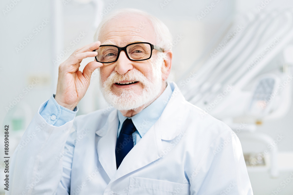 Brilliant experience. Close up of optimistic professional doctor standing in front of you while wearing white coat and having pleasant mood Brilliant experience. Close up of optimistic professional doctor standing in front of you while wearing white coat and having pleasant mood