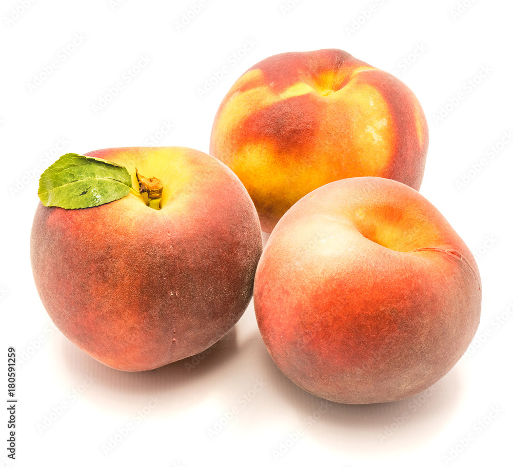 Three whole ripe peaches, one with green leaf, isolated on white background. Three whole ripe peaches, one with green leaf, isolated on white background.