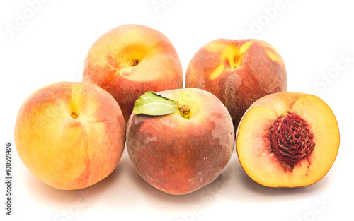 Group of whole peaches and one sliced half with a stone isolated on white background.