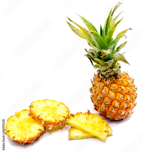 Fresh sliced pineapple and one whole with green leaves isolated on white background.