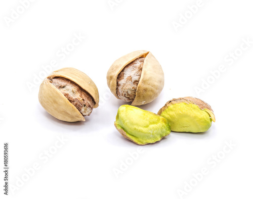 Two opened pistachio nuts, two without shells, isolated on white background.