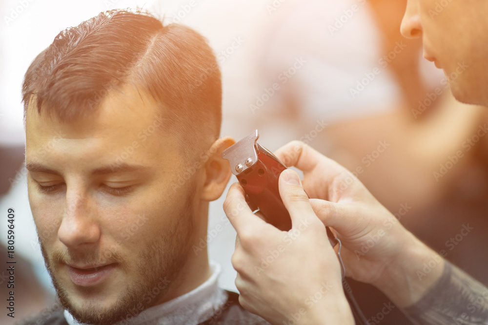 Naklejka premium Young handsome man in barbershop