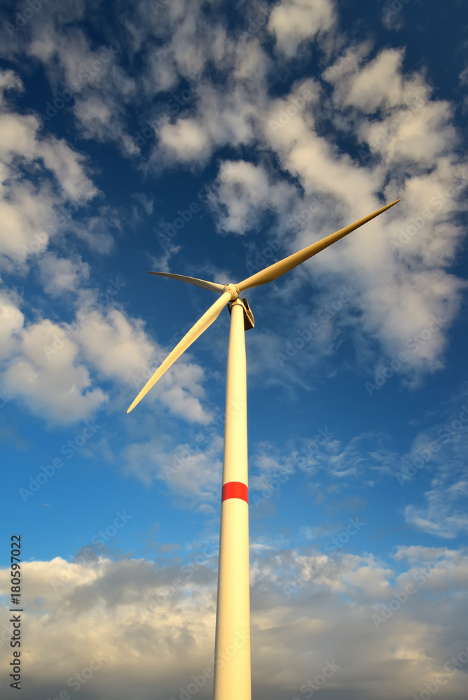 Wind turbines in landscape against blue sky and clouds Wind turbines in landscape against blue sky and clouds