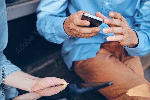 man with a phone in brown pants and a blue shirt