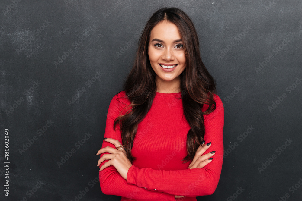 Smiling brunette woman in red blouse with crossed arms Smiling brunette woman in red blouse with crossed arms