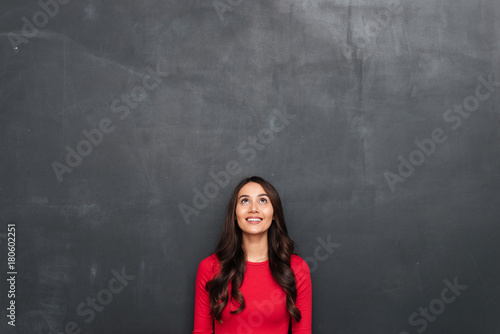 Picture of Happy brunette woman in red blouse looking up