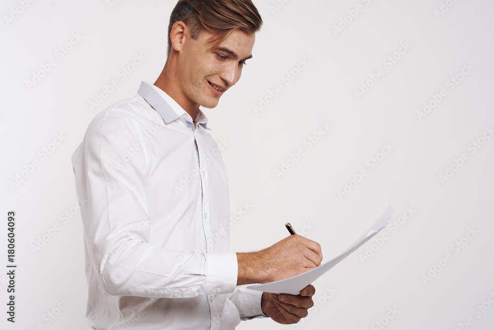 a young man in a white shirt happily signs a paper a young man in a white shirt happily signs a paper
