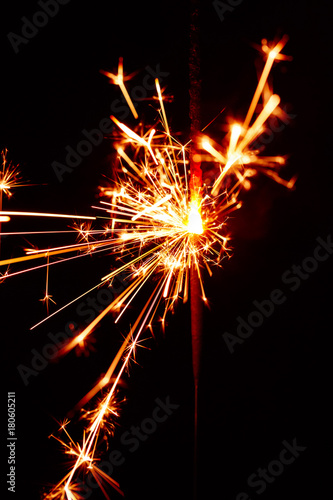 Burning sparkler isolated on black background blur