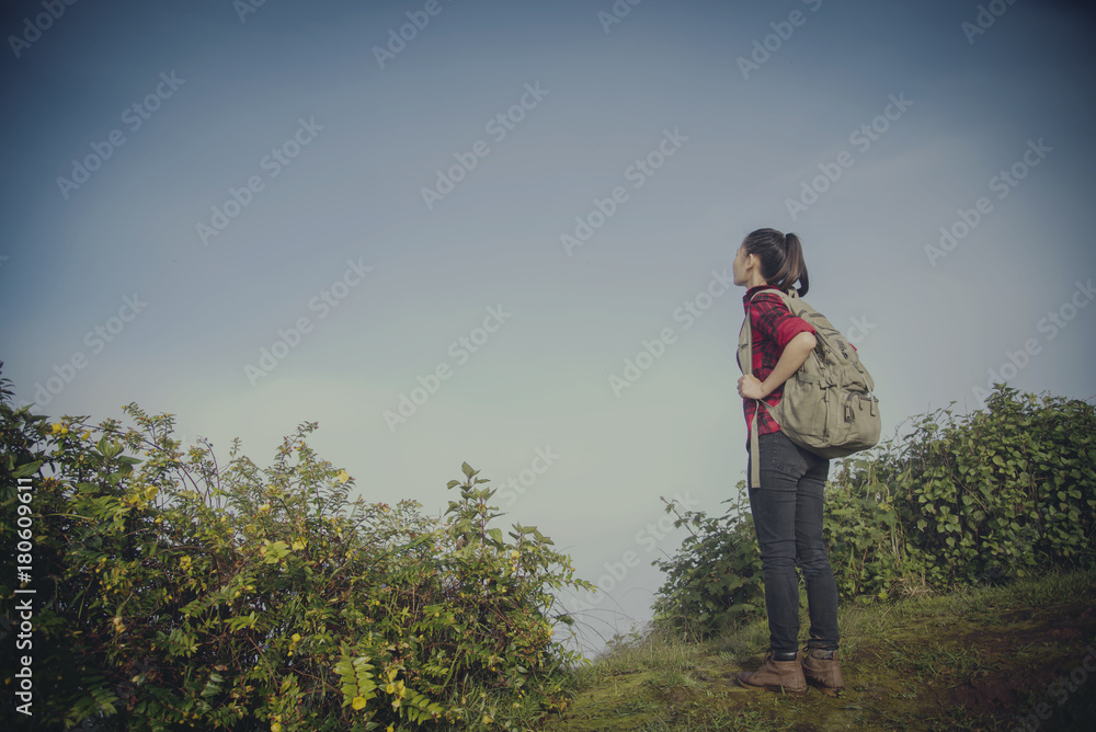 Hipster young girl with backpack enjoying sunset on peak of foggy mountain. Tourist traveler on background view mockup. Hiker looking sunlight in trip Hipster young girl with backpack enjoying sunset on peak of foggy mountain. Tourist traveler on background view mockup. Hiker looking sunlight in trip