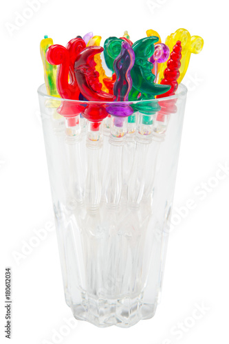 Colorful plastic swizzle sticks in glass on white background with Clipping Path.