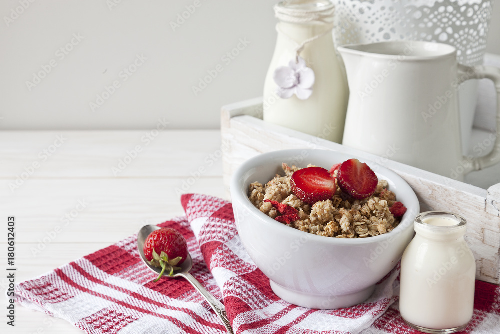 Ready breakfast - granola with a fresh ripe strawberry and milk with a miniature bottle. Close-up, useful product, background Ready breakfast - granola with a fresh ripe strawberry and milk with a miniature bottle. Close-up, useful product, background