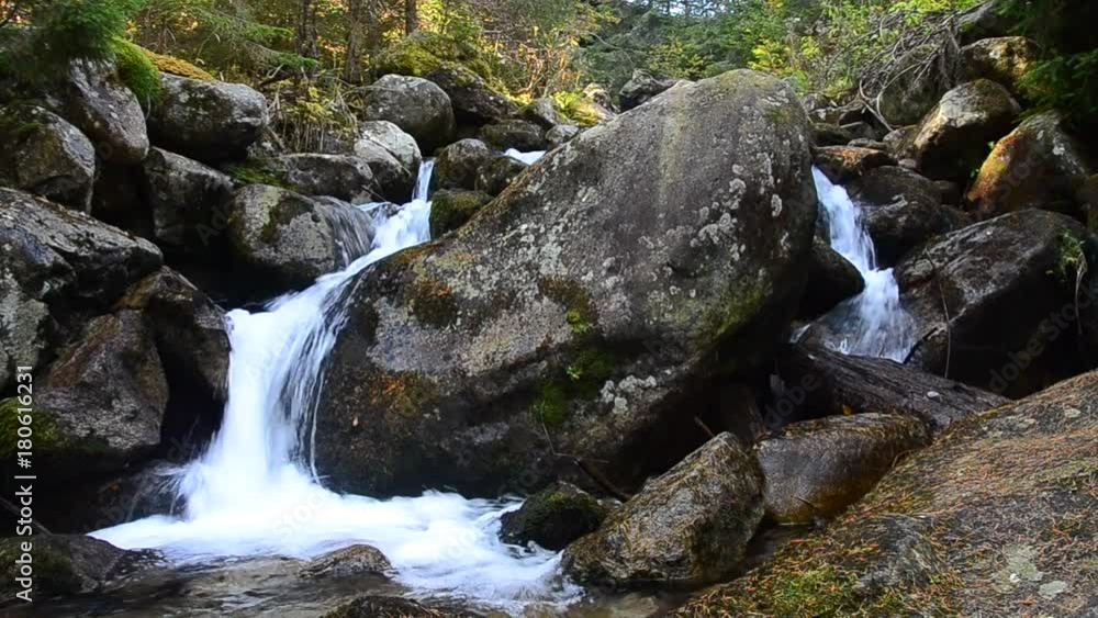 Mountain stream flowing through the large stones in deep forest. Mountain stream flowing through the large stones in deep forest.