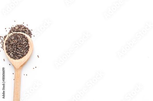 Superfood chia seeds in a wooden spoon on white background top view copyspace