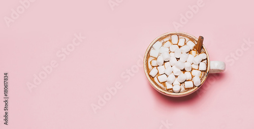 Cup of hot chocolate with marshmallows on pink background. top view, flat lay