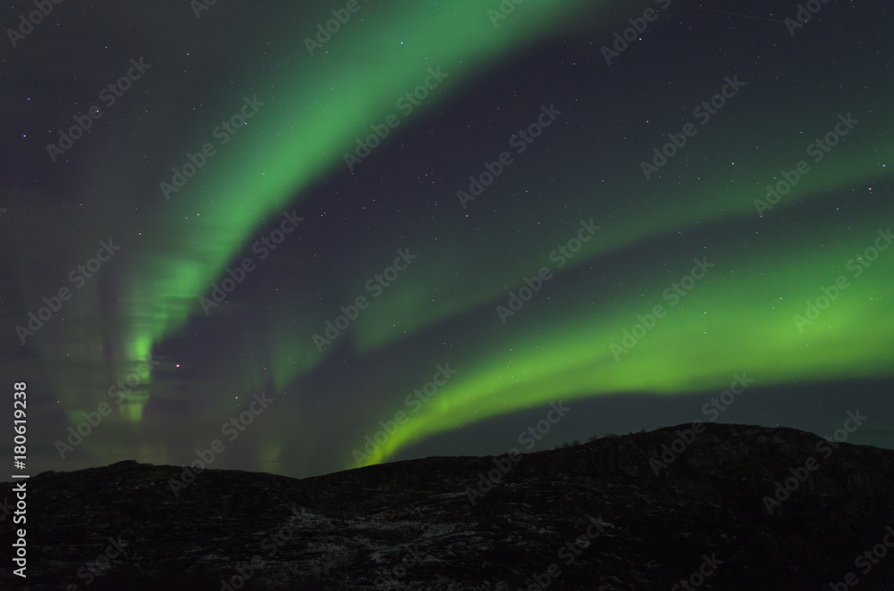 The Aurora in the night sky above the hills.