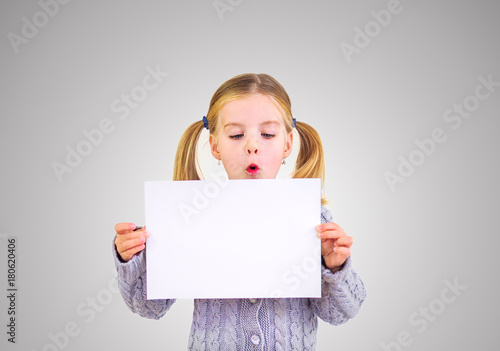 Девочка со светлыми волосами держит в руках пустой белый лист. Шаблон в руках у девочки.