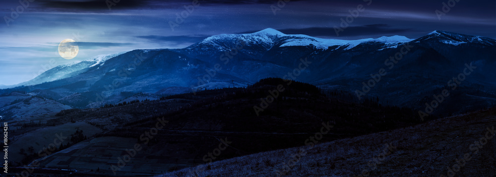 Fototapeta premium great mountain ridge Borzhava with snowy tops at night in full moon light. beautiful countryside landscape in late autumn