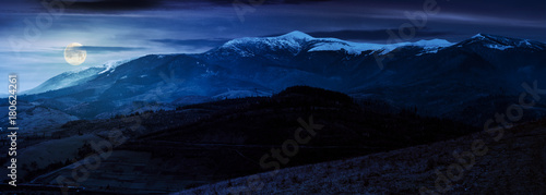 great mountain ridge Borzhava with snowy tops at night in full moon light. beautiful countryside landscape in late autumn photo