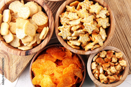 Salty snacks. Pretzels, chips, crackers in wooden bowls.