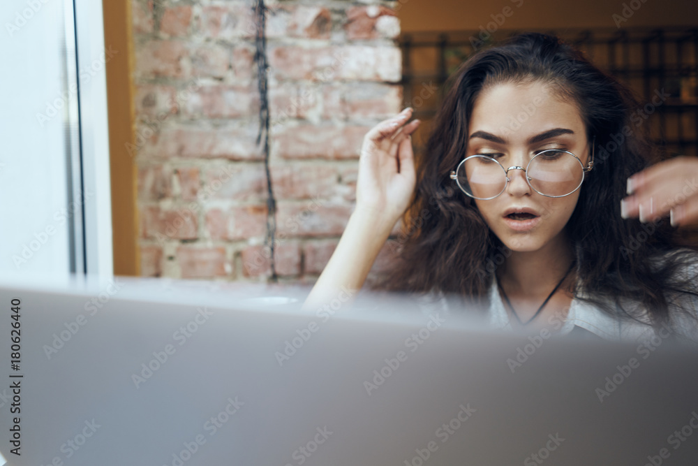 the girl is surprised by what she sees on the laptop