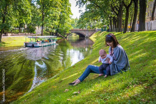 mother with child on the river bank in the summer park