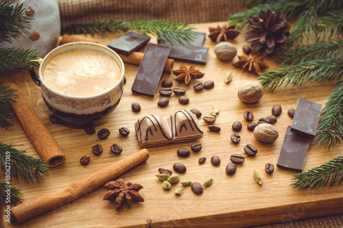 New Year's winter composition with coffee and spices in the kitchen on a wooden dinette and with pine branches. Beauty and inspiration with winter desserts. photo