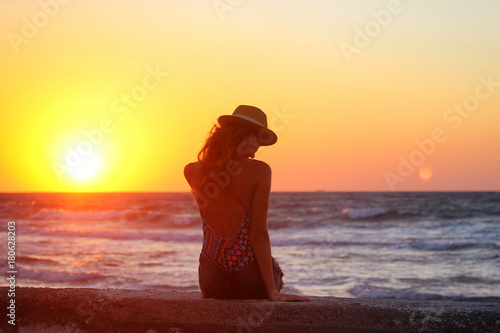 Young beautiful girl closeup near the sea at the sunset