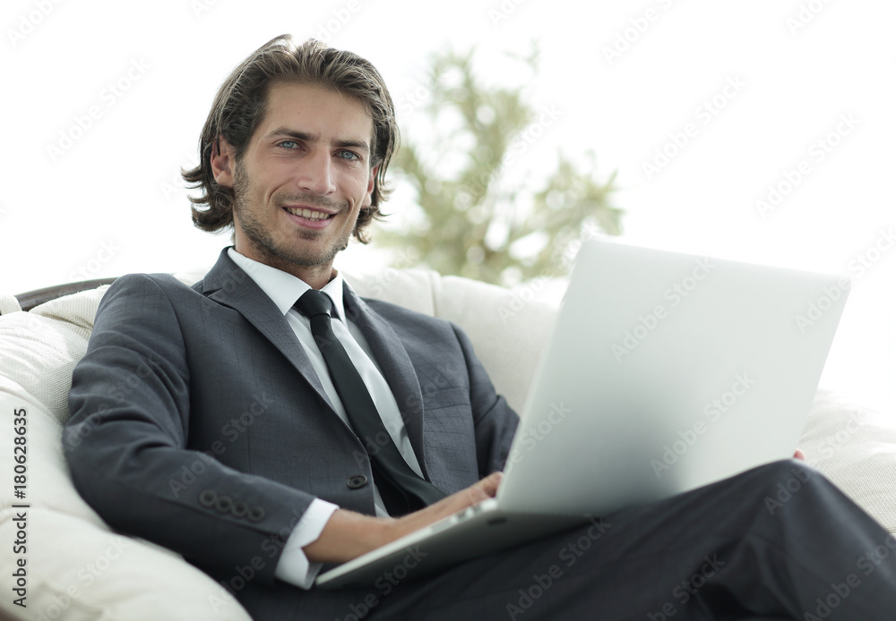 businessman with a laptop sitting in a stylish comfortable chai businessman with a laptop sitting in a stylish comfortable chai