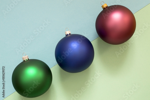Three Christmas tree balls on a multi-colored background