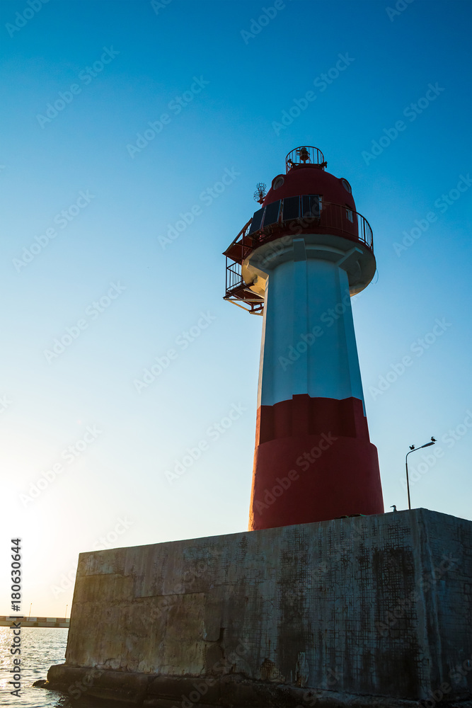 Low angle view of the lighthouse on the northern mole of Sochi at sunset, Russia
