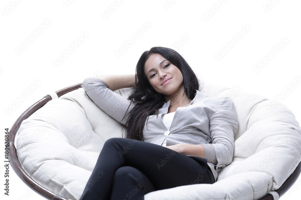 Fototapeta premium young woman sitting in a comfortable soft big armchair