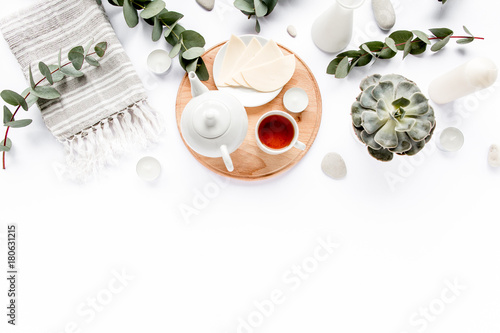 Breakfast with cheese, leaves eucalyptus, cutting board and black tea composition with on white background. Flat lay, top view