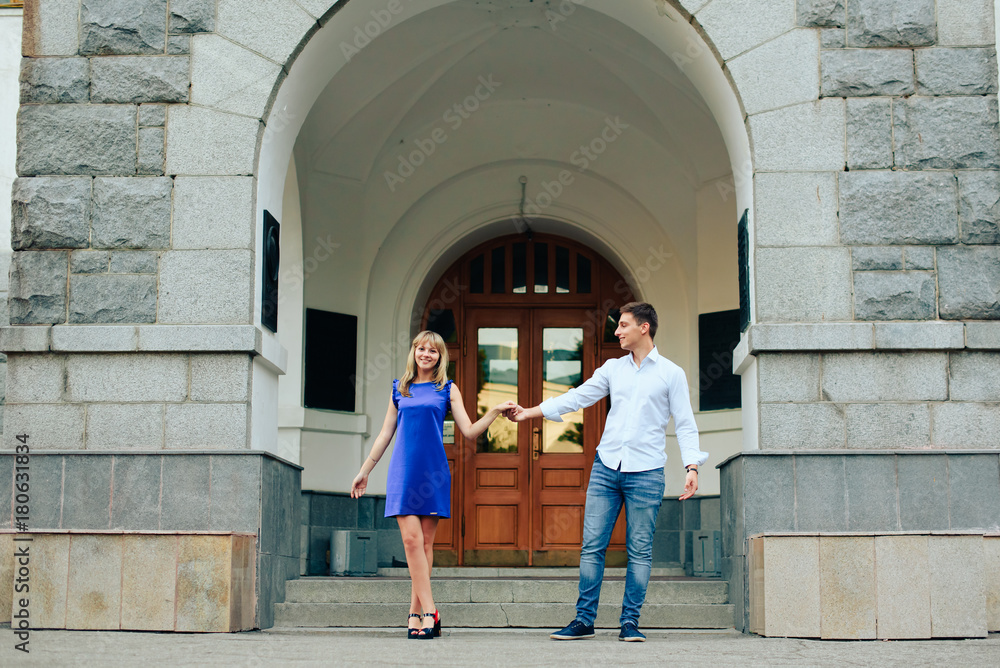 loving young couple walking around town man in white shirt and girl in blue dress