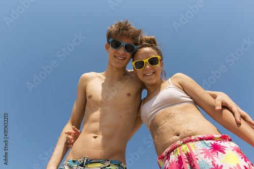 Brother and sister are laughing at the beach