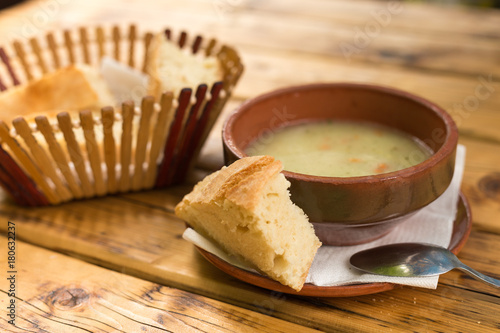 Vegetable cream soup and bread on a wooden table. Close-up.